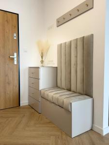 a bench in a room with a dresser and a door at Kaszmirowy Apartament in Mrągowo