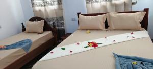 two beds with flower decorations on them in a bedroom at primavera jambiani in Mfumbwi +18 photos