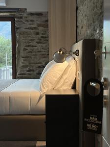 a bedroom with a bed with a lamp on a table at Villa Tua in Castanheiro