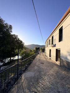 an empty street next to a building with a fence at Villa Tua in Castanheiro