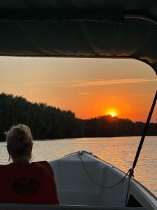 a person on a boat looking out at the sunset at Murighiol Excursii in Murighiol