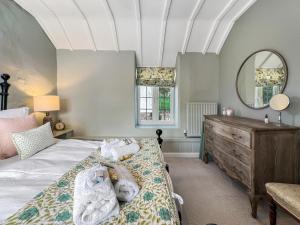 a bedroom with a bed with a dresser and a mirror at Sharpe Cottage Wiveliscombe in Wiveliscombe