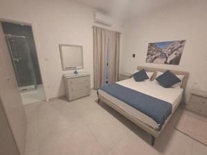 a bedroom with a bed and a dresser and a mirror at Luxury Waterfront 3BR Apartment with Large Terrace in Marsaskala