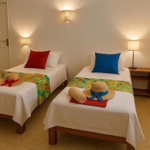 two beds with hats and towels on them in a room at Eagle Nest Residence -Appartement 1 in Port Maturin