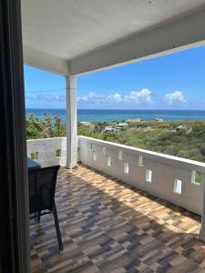 a balcony with a table and a view of the ocean at Eagle Nest Residence -Appartement 1 in Port Maturin