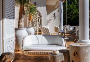 a wicker couch sitting on a porch with trees at Tranquil Algarve Escape in Faro