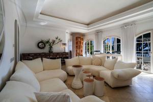 a living room with white furniture and windows at Tranquil Algarve Escape in Faro