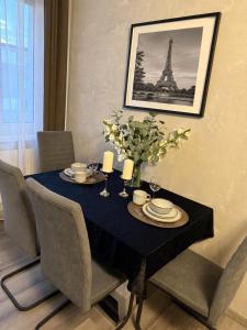 a dining room table with a blue table cloth and the eiffel tower at Incanto Apartament os Kopernika in Starogard Gdański +7 photos