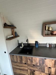 a kitchen with a black sink and wooden cabinets at The Hare's Lair in Monaghan +9 photos