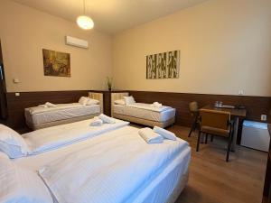a hotel room with two beds and a desk at Livora Boutique in Budapest