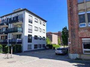 a white building with a car parked in front of it at Rooftop Apartment in Kornwestheim