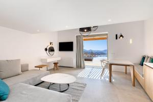 a living room with a couch and a table at Panormos Bay Suites Luxury Resort in Mikonos