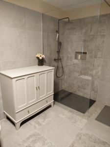 a bathroom with a white cabinet and a shower at Studio Lanisa in Kanal