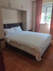 a bedroom with a large bed with white sheets at Apartman Budva in Budva