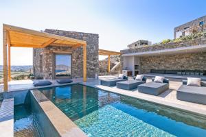 a villa with a swimming pool and a house at Panormos Bay Suites Luxury Resort in Mikonos