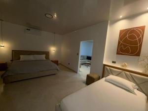 a bedroom with two beds and a painting on the wall at Suite Rosedelco in Puerto Villamil +6 photos