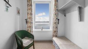 a room with a chair and a window at Williams Haven in Rothesay