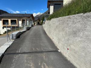 an empty street next to a house with a mountain at Mountain spot in a cozy nest in Airolo
