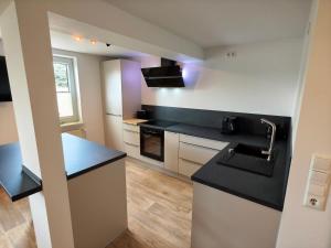 a kitchen with a black counter and a sink at Gasthaus Harmonie in Malchow