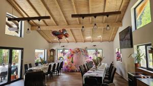 a dining room with tables and chairs with butterflies on the wall at CozyCloud in Poiana Mărului