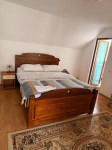 a bedroom with a bed with a wooden frame at CozyCloud in Poiana Mărului