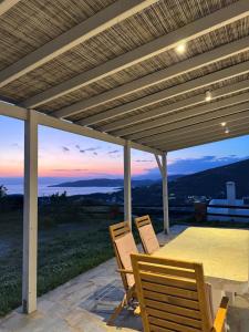 eine Terrasse mit Tisch und Stühlen unter einer Pergola in der Unterkunft Stivari view in Batsi