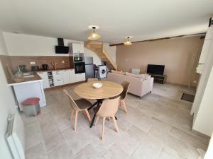 a kitchen and living room with a table and chairs at Au pré de Mimi in Lalande-en-Son