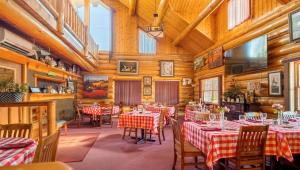 a restaurant with red and white tables and chairs at Dodge Peak Lodge in Bonners Ferry