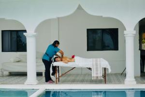 a woman laying on a bed next to a pool at Casa del Viento Celestun in Celestún