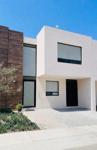 a white house with black windows at Comfortable, equipped house for long stays in Juriquilla