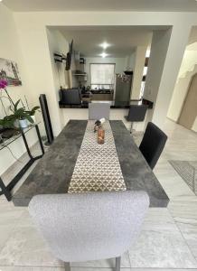 a dining table and chairs in a living room at Comfortable, equipped house for long stays in Juriquilla