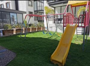 a playground with a slide on the grass at Comfortable, equipped house for long stays in Juriquilla