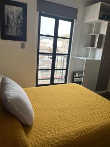 a bedroom with a yellow bed with a pillow on it at Hotel Angeles in Ciudad Serdán