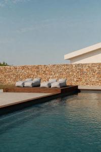 a row of pillows on benches next to a body of water at Tenute Allegretti Casa in Montalbano +27 photos