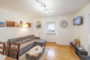 a living room with a couch and a clock on the wall at Castua Residence in Kastav
