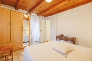 a bedroom with a white bed and a wooden ceiling at Castua Residence in Kastav