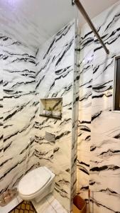 a bathroom with a toilet and a marble wall at مدينة الشرق الزرقاء in Az Zarqa