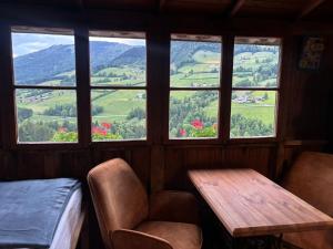 a room with a table and chairs and windows at Sommerkino in Krispl +12 photos