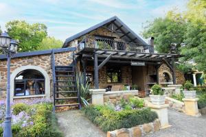 a stone building with a staircase and a balcony at Flitwick Ranch in Swartberg