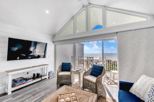 a living room with a tv and a couch at Coconuts Beachfront #112 in Holmes Beach