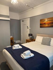 a bedroom with a bed with towels on it at Sterling Lodge Hotel in Eastbourne