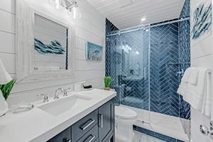 a bathroom with a sink and a shower at Coconuts Beachfront #112 in Holmes Beach +16 photos