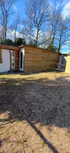 a house with a fence and a chair in front of it at studio love et detente in Saint-Philbert-sur-Risle