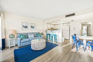 a living room with a couch and a table at Coconuts Poolside #115 in Holmes Beach