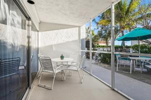 a patio with a table and chairs and an umbrella at Coconuts Poolside #115 in Holmes Beach