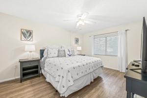 a bedroom with a bed and a ceiling fan at Coconuts Poolside #115 in Holmes Beach