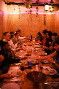 a group of people sitting around a long table at Eco Bay Surf Camp in Aourir