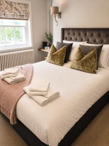 a large white bed with two towels on it at The Gregory Arms in Harlaxton