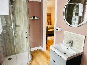 a bathroom with a shower and a sink and a mirror at Brackengarth House in Purdysburn +44 photos