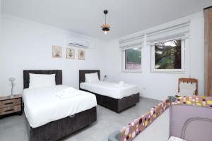 a bedroom with two beds and a table and a couch at Villa Kısmet in Fethiye +54 photos